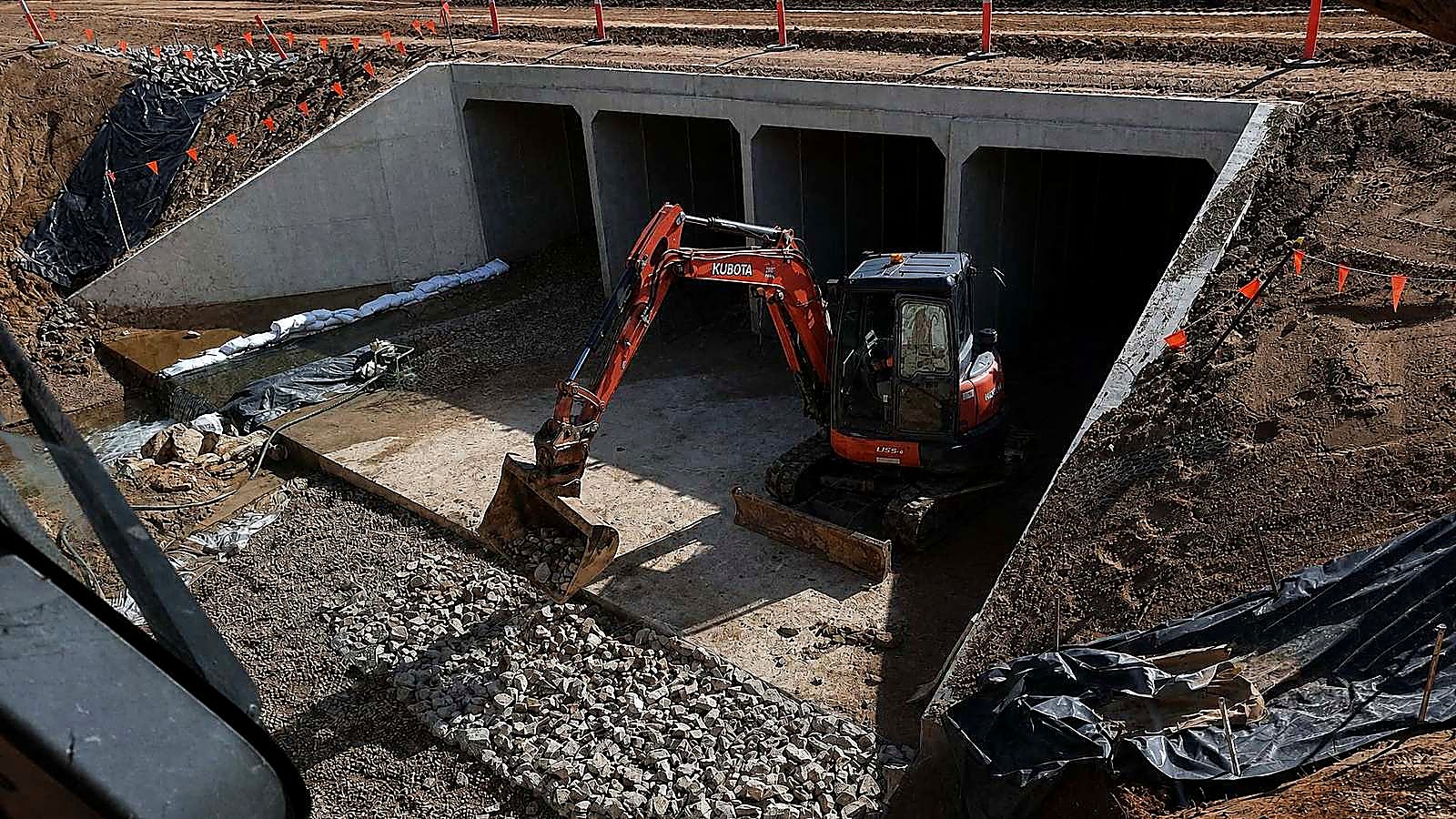 AreeCivil Constructions excavation at a concrete culvert Kubota excavator placing rock in a three-cell box culvert on a South East Queensland civil site